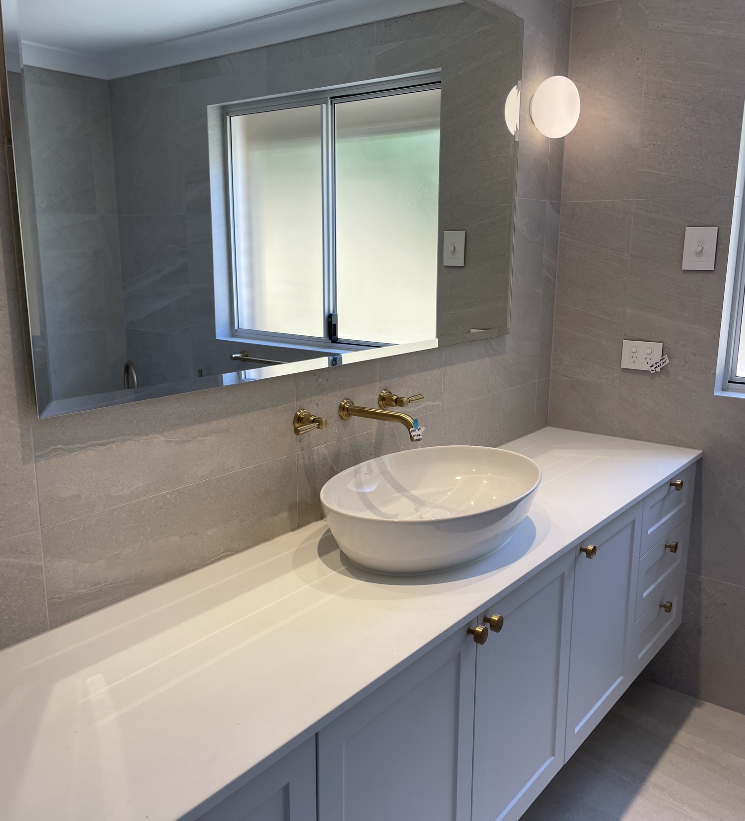 Finished HomeCheck WA bathroom with a white vanity, vessel basin and brass tapware